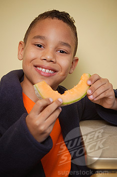 Boy eating cantaloupe